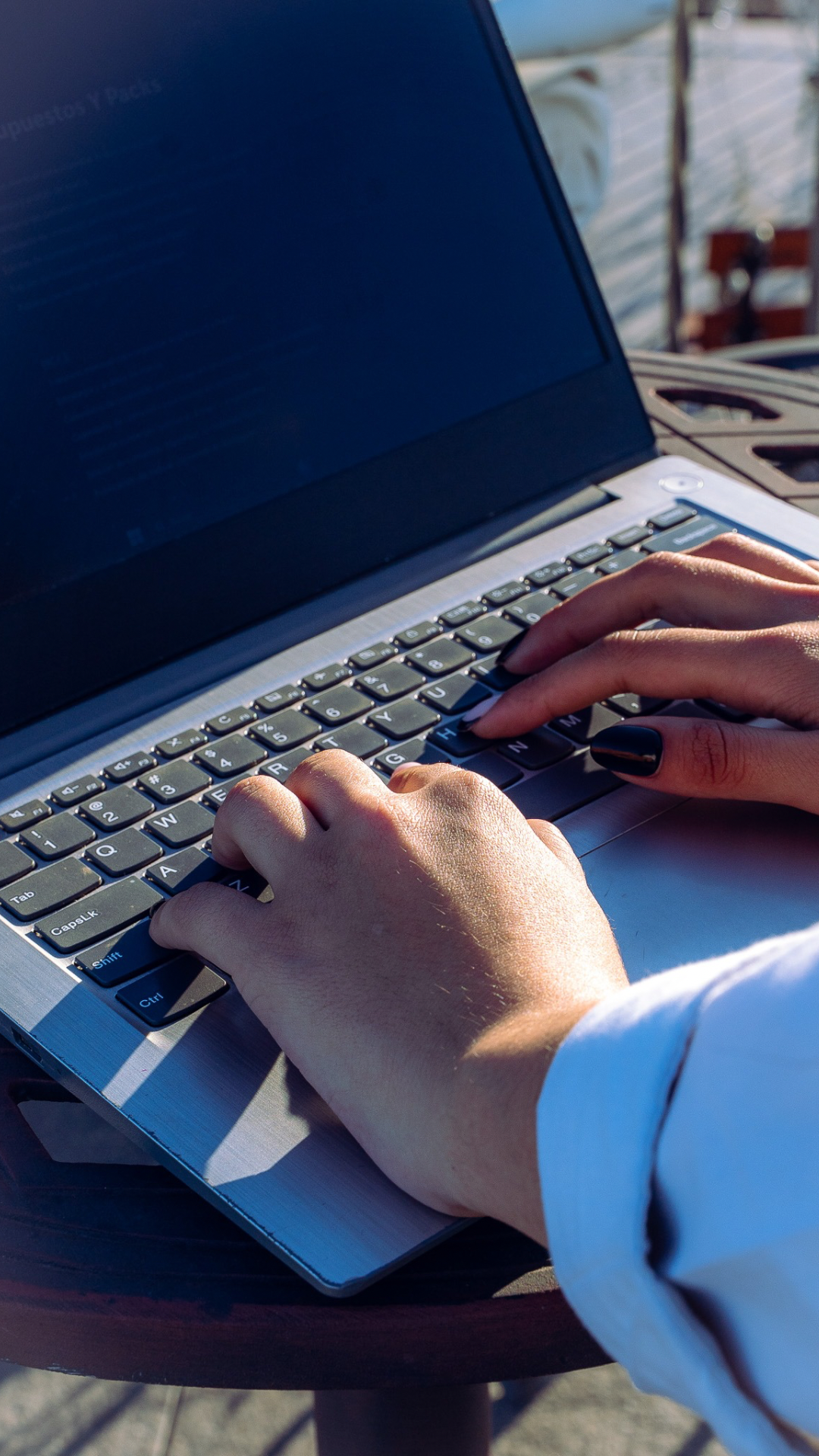 Manos trabajando en una computadora portátil